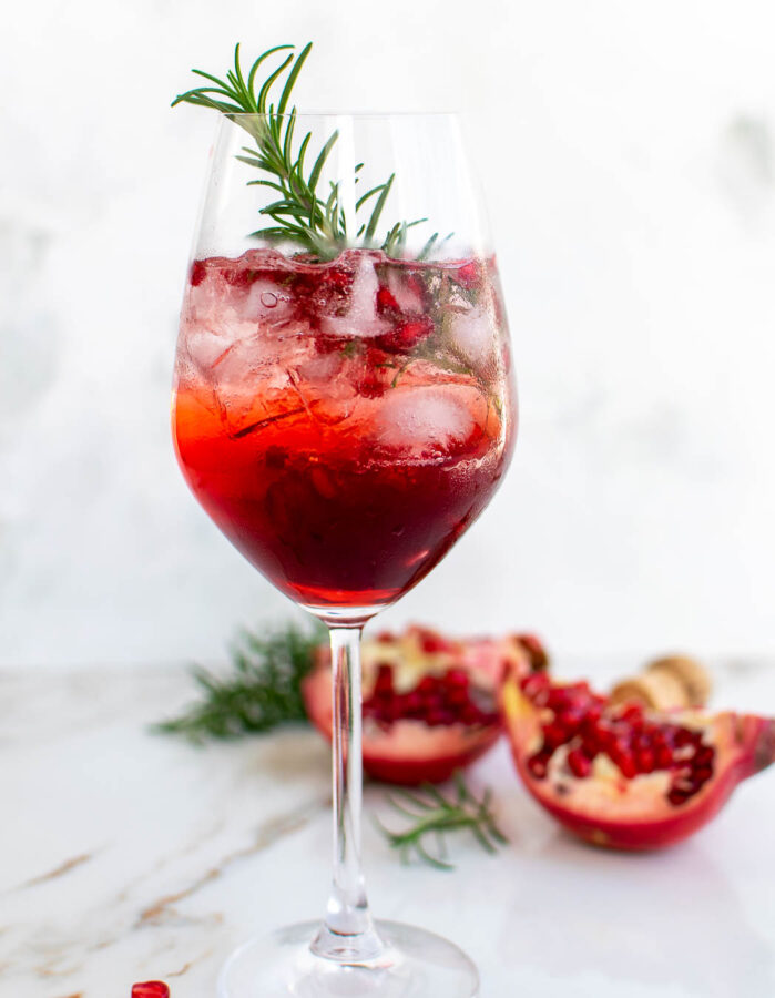 Pomegranate Campari Spritz garnished with rosemary.