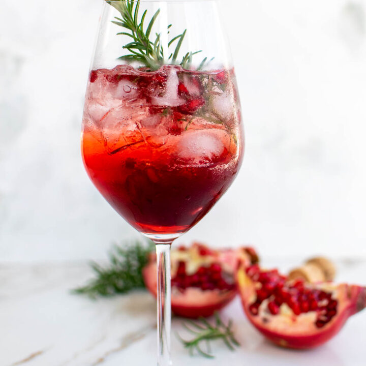 Pomegranate Campari Spritz garnished with rosemary.